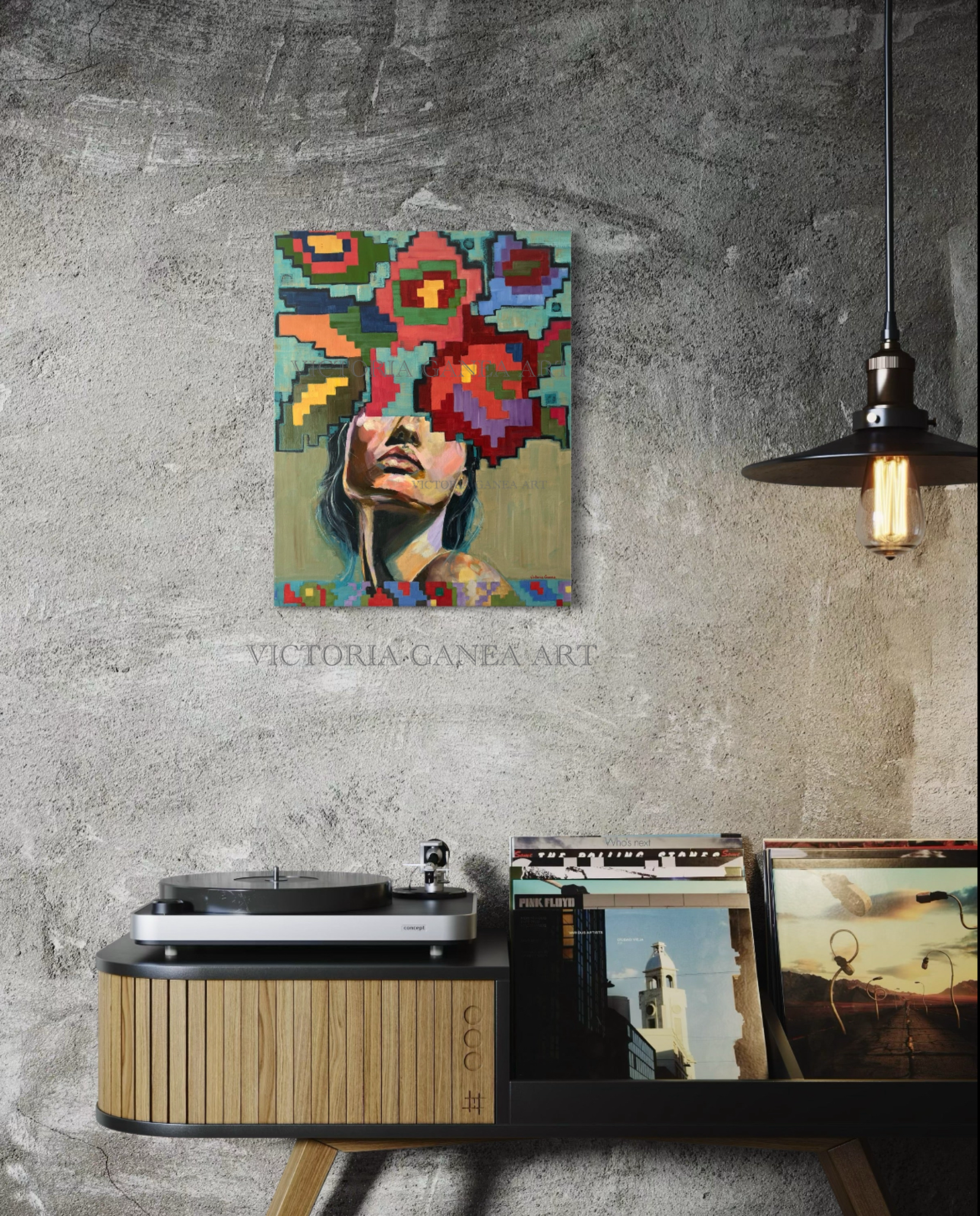 Colorful abstract art piece on a gray wall above a record player.